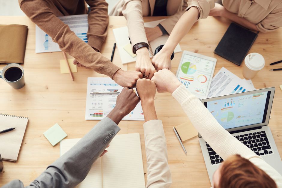 Grupo de personas conversando alrededor de una mesa en una sala de reuniones luminosa